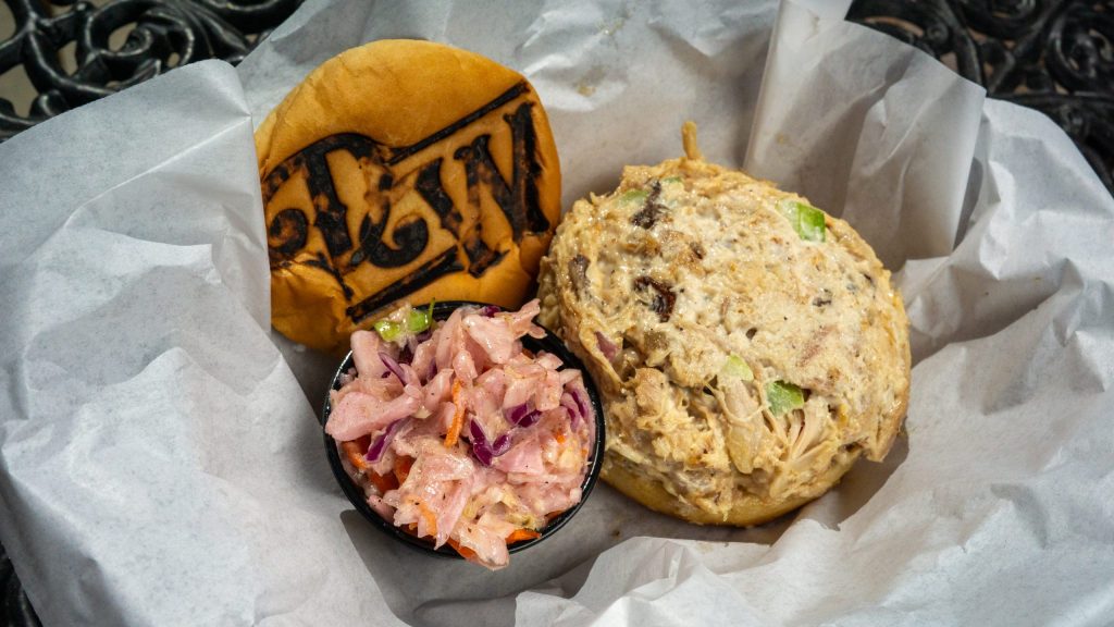 Pulled pork sandwich with coleslaw in a basket.